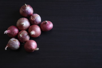 group of onions on a dark wooden table