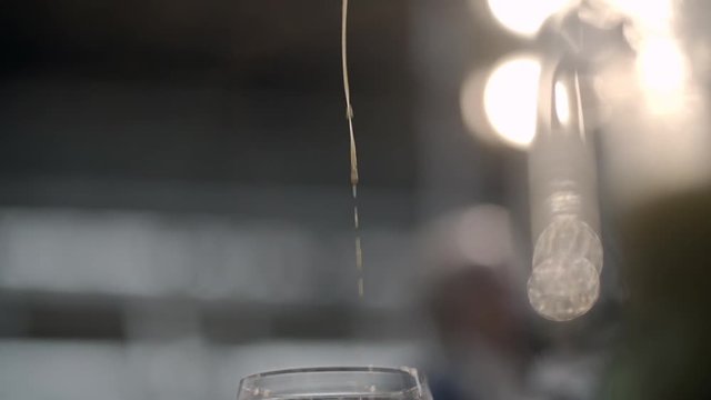 closeup of a bartender dripping a cocktail in a glass