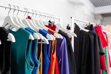 Obraz premium Cocktail dress. Clothing on hanger at the modern shop boutique. Bright multi-colored fabrics. concept of shopping.