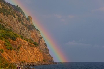 Fototapeta na wymiar Rainbow over mountain and sea