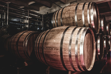 Wooden barrels with whiskey in dark cellar