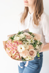 Delicate bouquet of mixed flowers in womans hands. the work of the florist at a flower shop. Delicate Pastel color. Fresh cut flower. White and pink color
