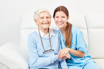 Pflegedienst bei glücklicher Seniorin zu Hause