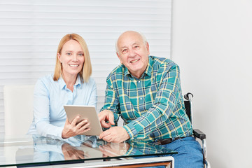 Neugieriger Senior und junge Frau mit Tablet