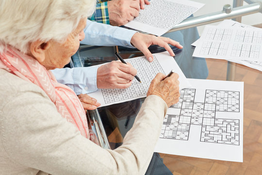 Alte Frau löst Sudoku Rätsel als Gedächtnistraining