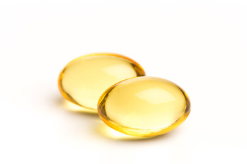 Close up golden color oil supplements in soft gel capsule, healthy product concept