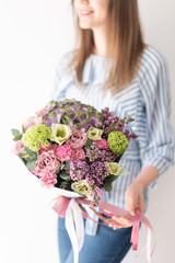 cute bouquet of mixed flowers in womans hands. the work of the florist at a flower shop. Delicate Pastel color. Fresh cut flower.