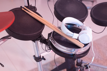 Musical instruments, hobby and music concept - headphone, drumsticks on drum