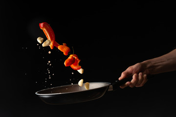 chef preparing vegetables in a skillet