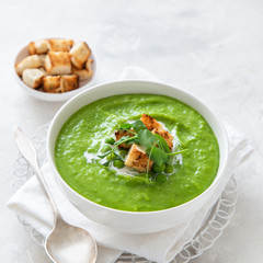 vegan green peas cream soup in white bowl