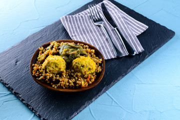 Chicken cutlets with buckwheat porridge on blue plate on wooden table.