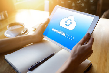 Cloud synchronization progress bar on tablet screen. Data storage and protection. Technology and...
