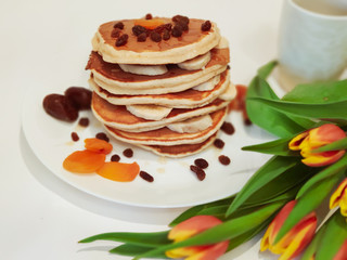 Stack of Pancakes on the Table with Tulips
