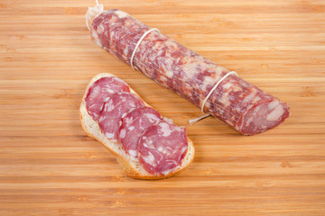 Open sandwich with dry-cured sausage and not sliced sausage