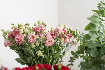 flower shop concept. Vases with different flowers on wooden table. Wallpaper
