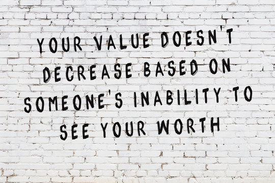 White brick wall with painted black motivational quote inscription