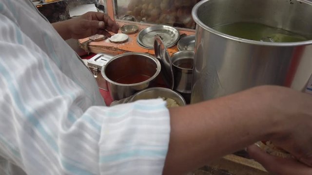 Slow motion prep of Panipuri or Golgappa, consists of a round, hollow puri, fried crisp filled with mix of flavored water, tamarind chutney, chili, chaat masala, potato, atta, chickpea. stabilized 4k