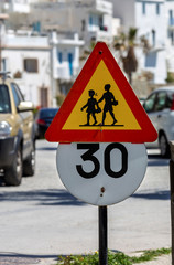Sign "Caution children" and sign "Speed limit" close-up.