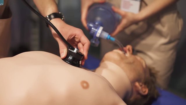 Emergency, training of medical personnel and ambulance doctors, doctors reanimate a man's dummy, doctor with stethoscope check a patient's.