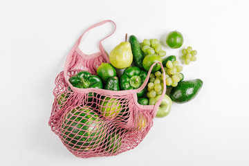 Mesh market bag with Assorted Raw Fresh Organic Green Vegetables. Flat lay, top view