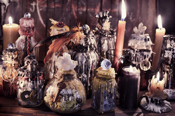 Witch bottles and candles in magic candlelight on the table