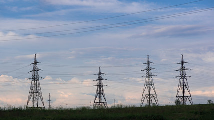 Power lines and sky with clouds.Wires over the fields.Powerful lines of electric gears.Electric power industry and nature concept.High voltage power lines.