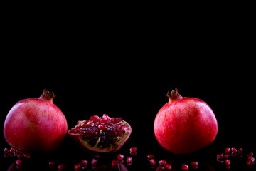 fresh ripe pomegranate on a black backgroundgarnet in the section. pomegranate