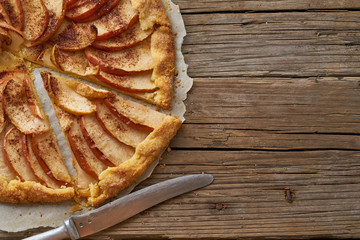 Apple pie, galette with a fruits, sweet pastries on old wooden rustic table. Part of pie, copy space