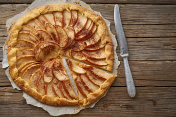 Apple pie, galette with a fruits, sweet pastries on old wooden rustic table, copy space
