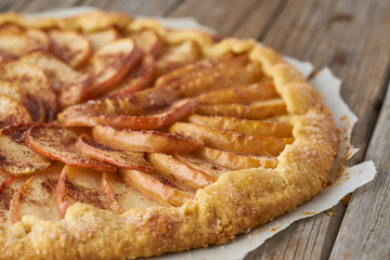 Apple pie, galette with a fruits, sweet pastries on old wooden rustic table, side view, close up, selective focus
