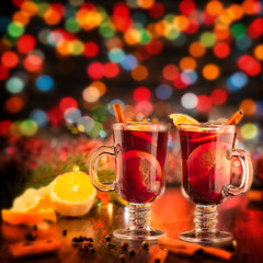 Christmas mulled red wine with spices and fruits on a wooden rustic table. Traditional hot drink at Christmas time