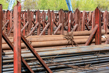 Metal rolling. A round tube are stacked in storage for sale and loading in stock in the open air.