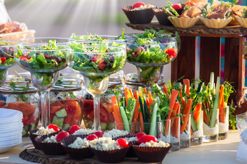 Beautifully decorated catering banquet table with different food snacks and appetizers with sandwich at sunny day