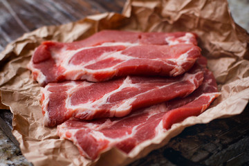 Fresh sliced meat on craft paper background. Cooking process. 