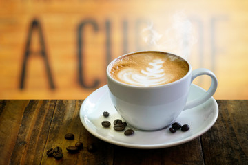 Coffee cup on wooden table on blurred of interior coffee shop. Business time with coffee, Coffee color brown background for product display, free copy space. Industrial food, drink background concept.
