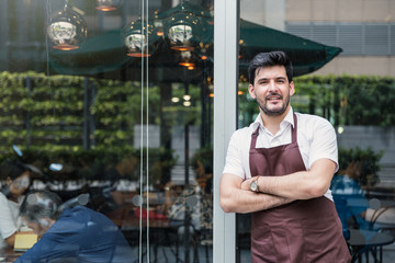 Startup successful small business owner man walking in his coffee shop or restaurant. Portrait of young caucasian man successful barista cafe owner