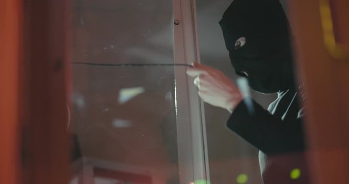 Anonymous hacker in black mask steals information