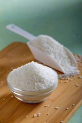 Sugar in glass bowl on wooden background