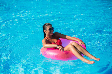 Sexy woman in bikini tanning during holidays in pool