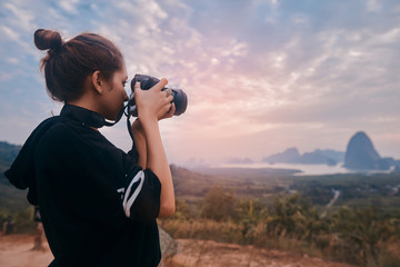 Rear view of a young woman photographer shooting the awesome view of Ao Phang Nga National Park - obrazy, fototapety, plakaty