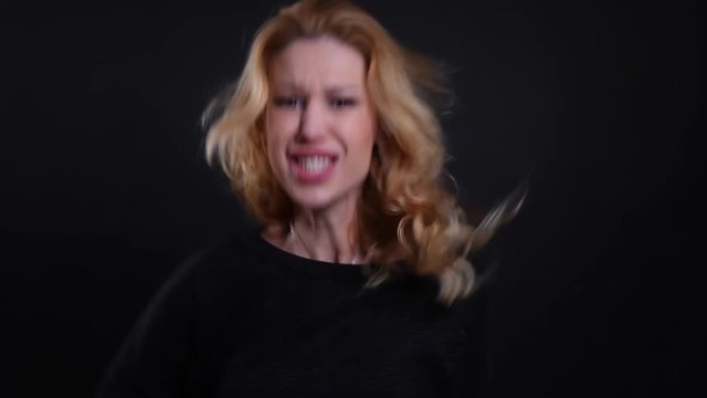Closeup portrait of adult attractive redhead female being angry and screaming with rage looking at camera with background isolated on black