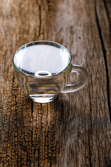 water in cup on wooden background 
