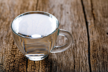 water in cup on wooden background 