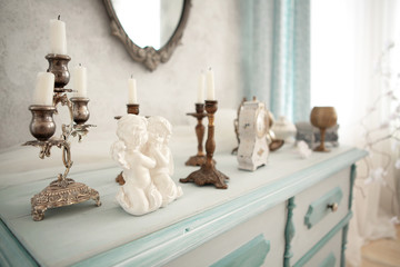 Beautiful home interior. Rustic style turquoise  cupboard. Plaster statuette of angels on the shelf
