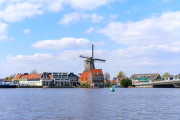 Fototapeta na wymiar Historic Dutch Windmill in Zaanse Schans on the Zaan River in the Netherlands
