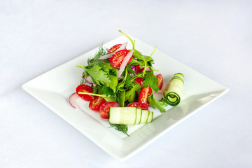 Spring salad with radishes, cucumbers and tomato.