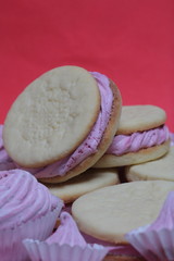 Cooked marshmallow sandwiches. They lie on plate. Next on the plate is a marshmallow of various sizes.