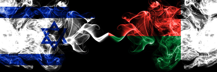 Israel vs Madagascar, Madagascan smoky mystic flags placed side by side. Thick colored silky smokes flag of Israel and Madagascar, Madagascan