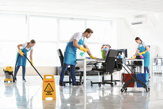 Team of janitors cleaning office