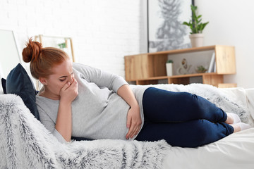 Obraz premium Young pregnant woman suffering from toxicosis at home